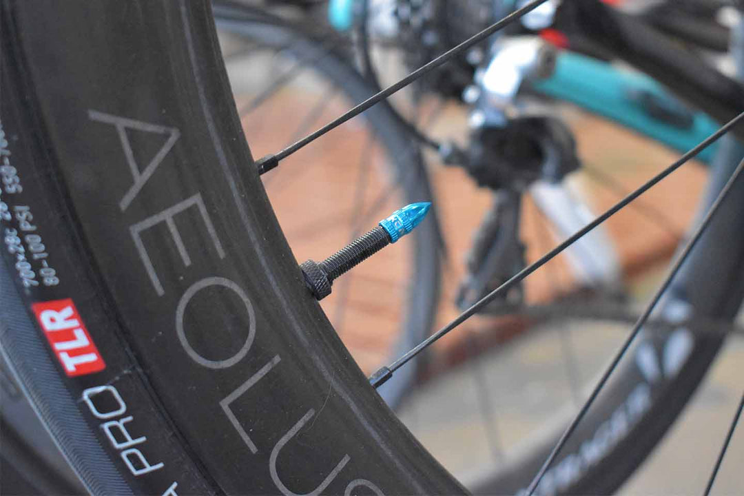 アルミ製の青いバルブキャップを付けたロードバイクの写真