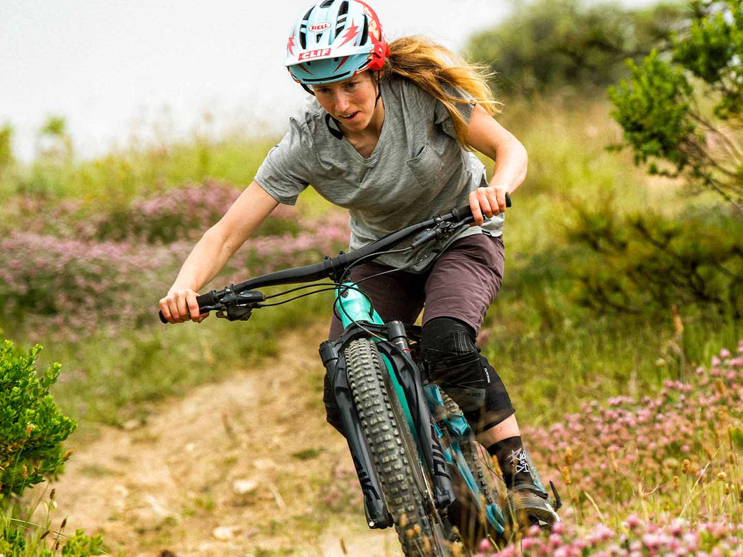 広いハンドル幅のフルサスマウンテンバイクを操る女性ライダーの写真