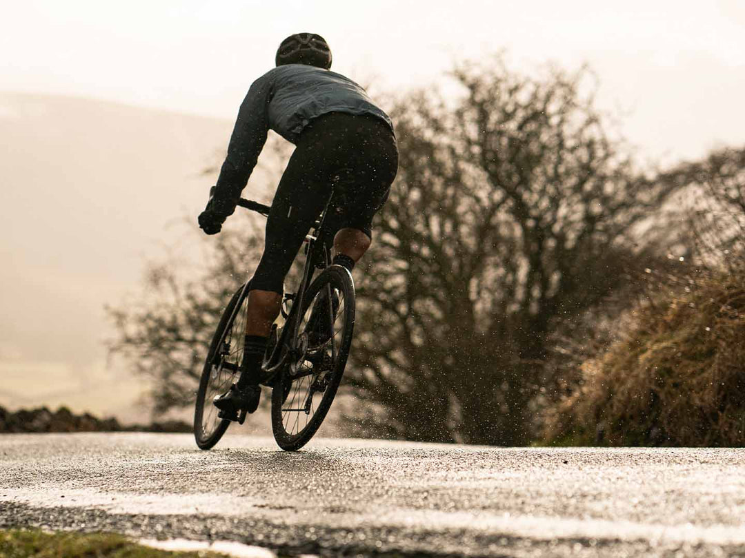 雨に濡れた路面のコーナーを走るロードバイクの写真