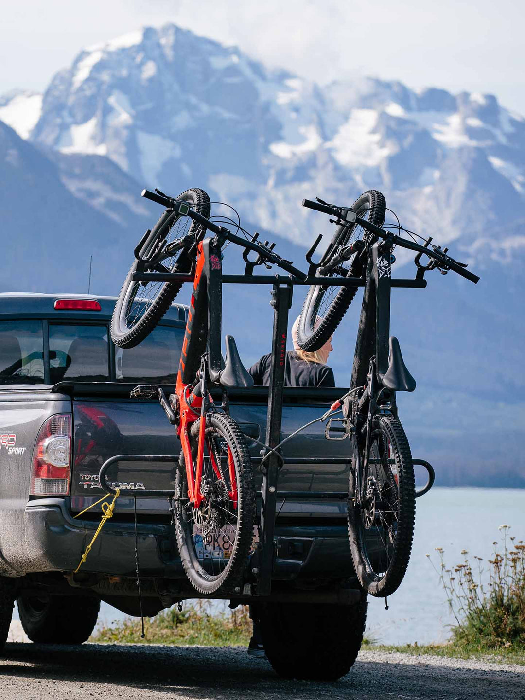 トラックの後ろに車載されたeMTB。遠くに雪が残る岩山を臨む写真