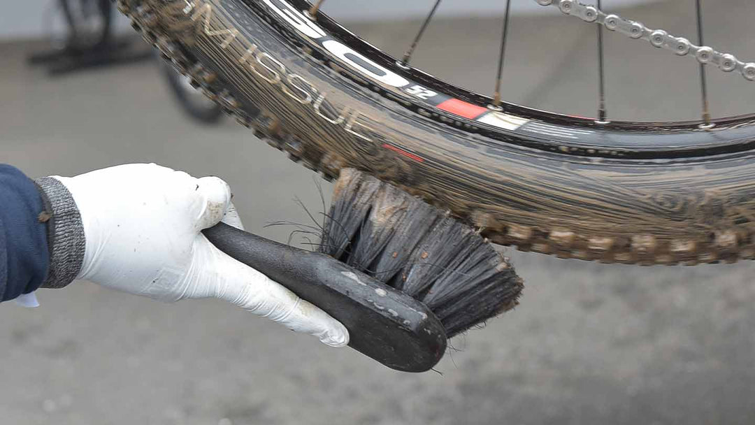 専用のブラシでタイヤに付着した泥を洗浄している様子
