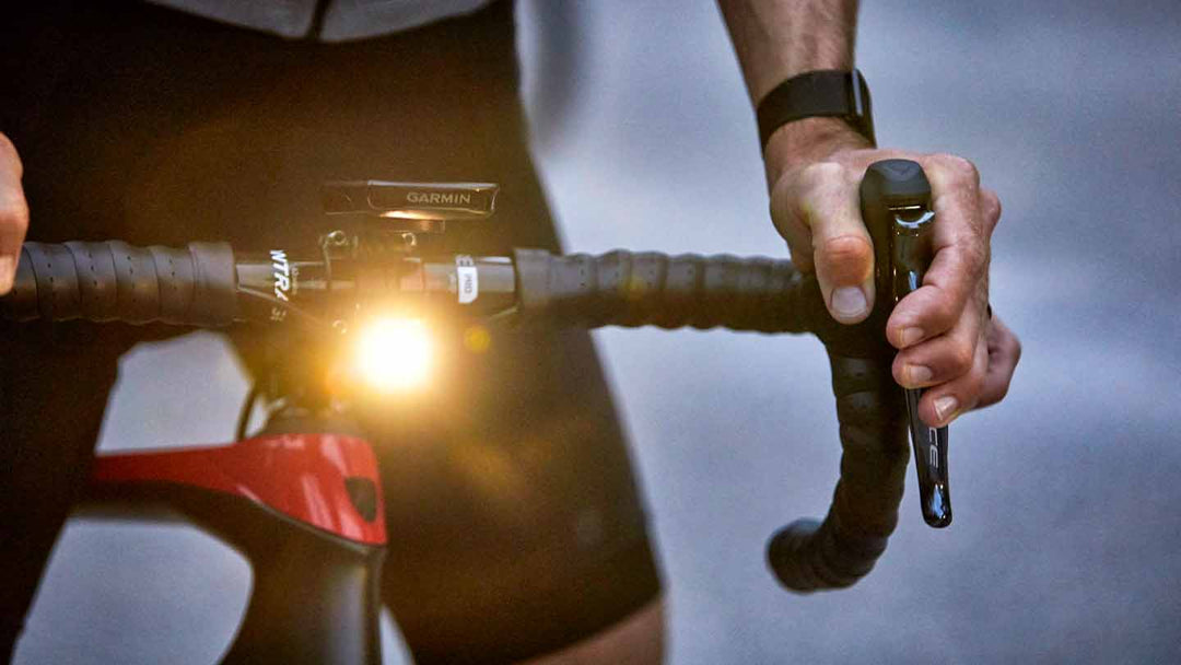 明るく点灯しているロードバイクのフロントライトの写真