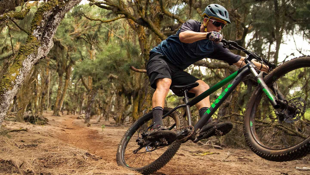 マニュアルをしてトレイルを走り抜けるマウンテンバイカーの写真