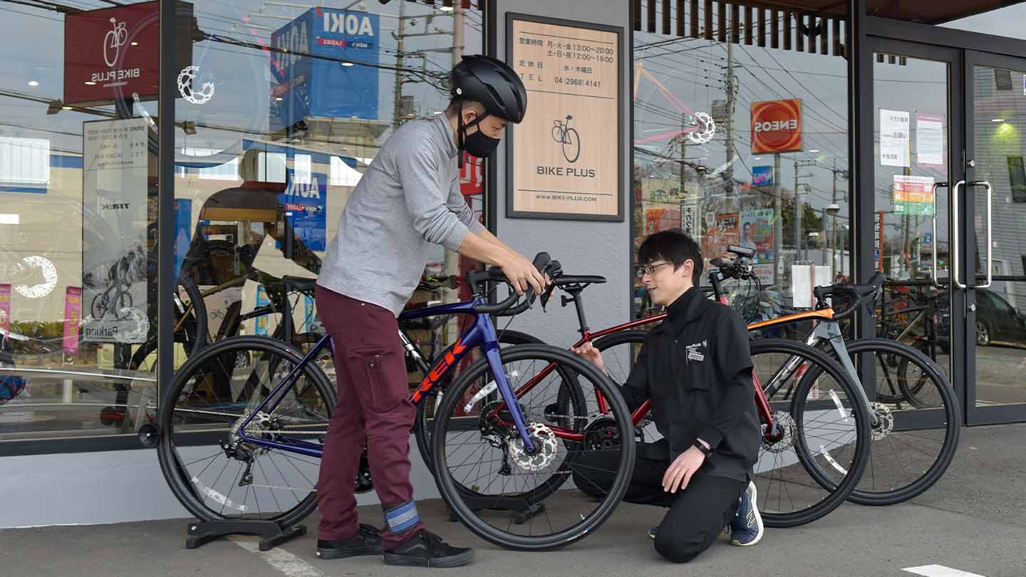 ロードバイクの試乗の前みブレーキなどの使用方法をお客様にお伝えしているイメージ写真