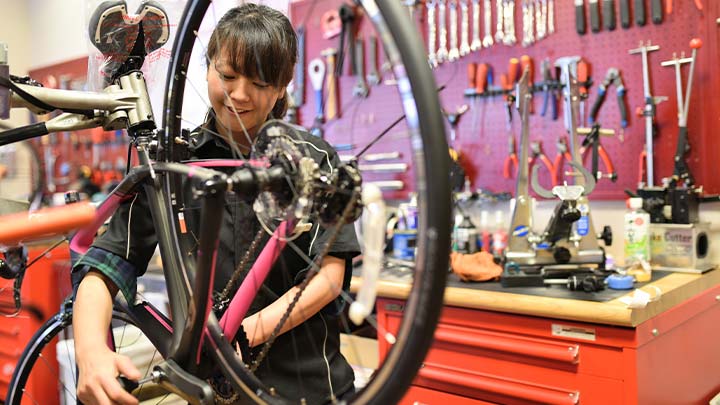 女性用ロードバイクをメンテナンスするスタッフの様子