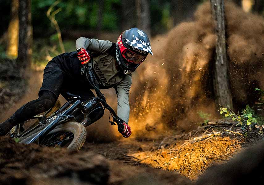 フルフェイスのヘルメットを被りエンデュー用フルサスマウンテンバイクでロレースの練習をしている様子