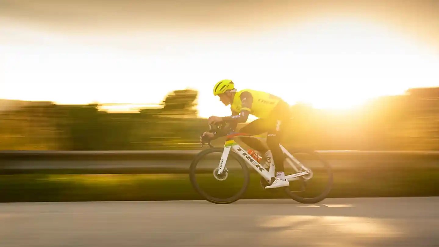 世界選手権覇者がロードバイクで夕陽を浴びながら疾走している様子