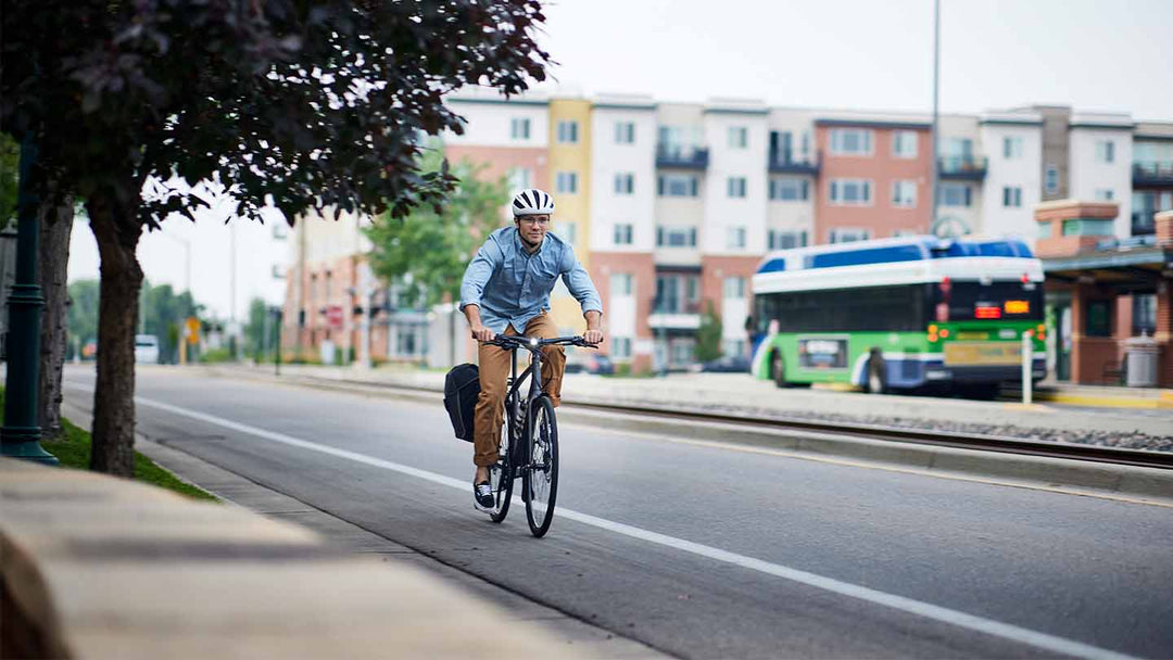 自転車通行帯をライトを点灯させてクロスバイクで走行する男性