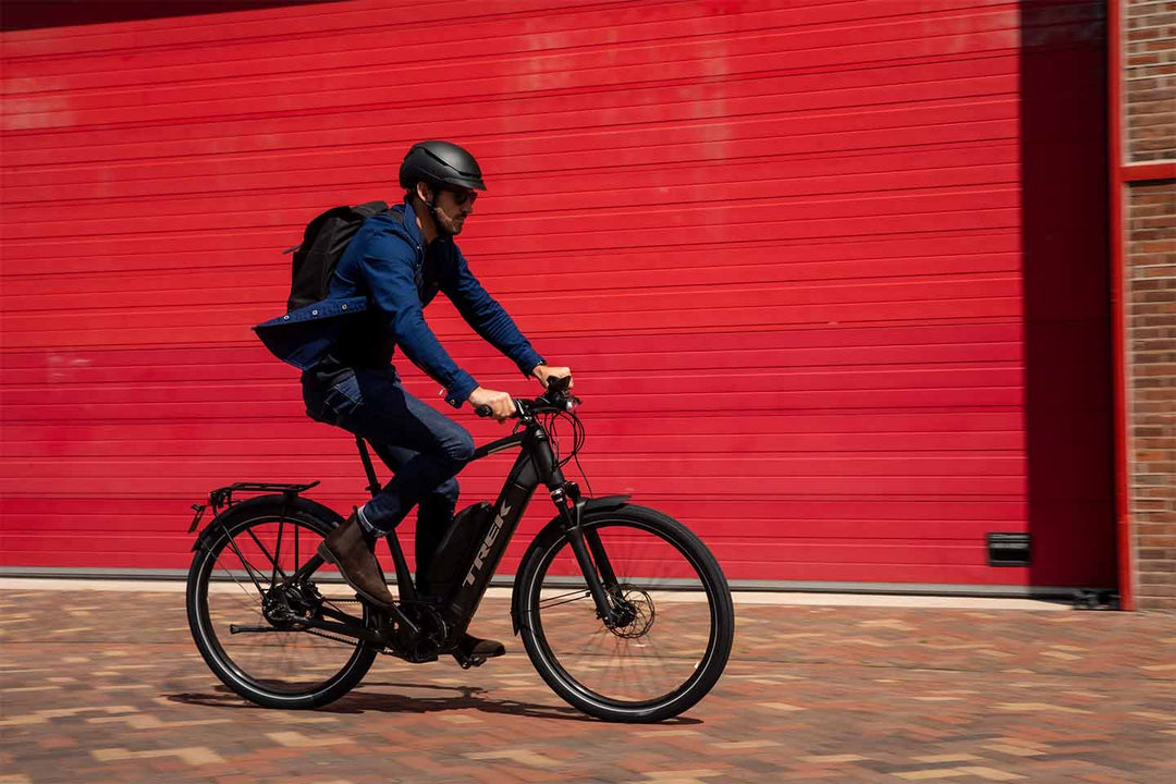Eバイクで街中を通勤する海外の男性の写真