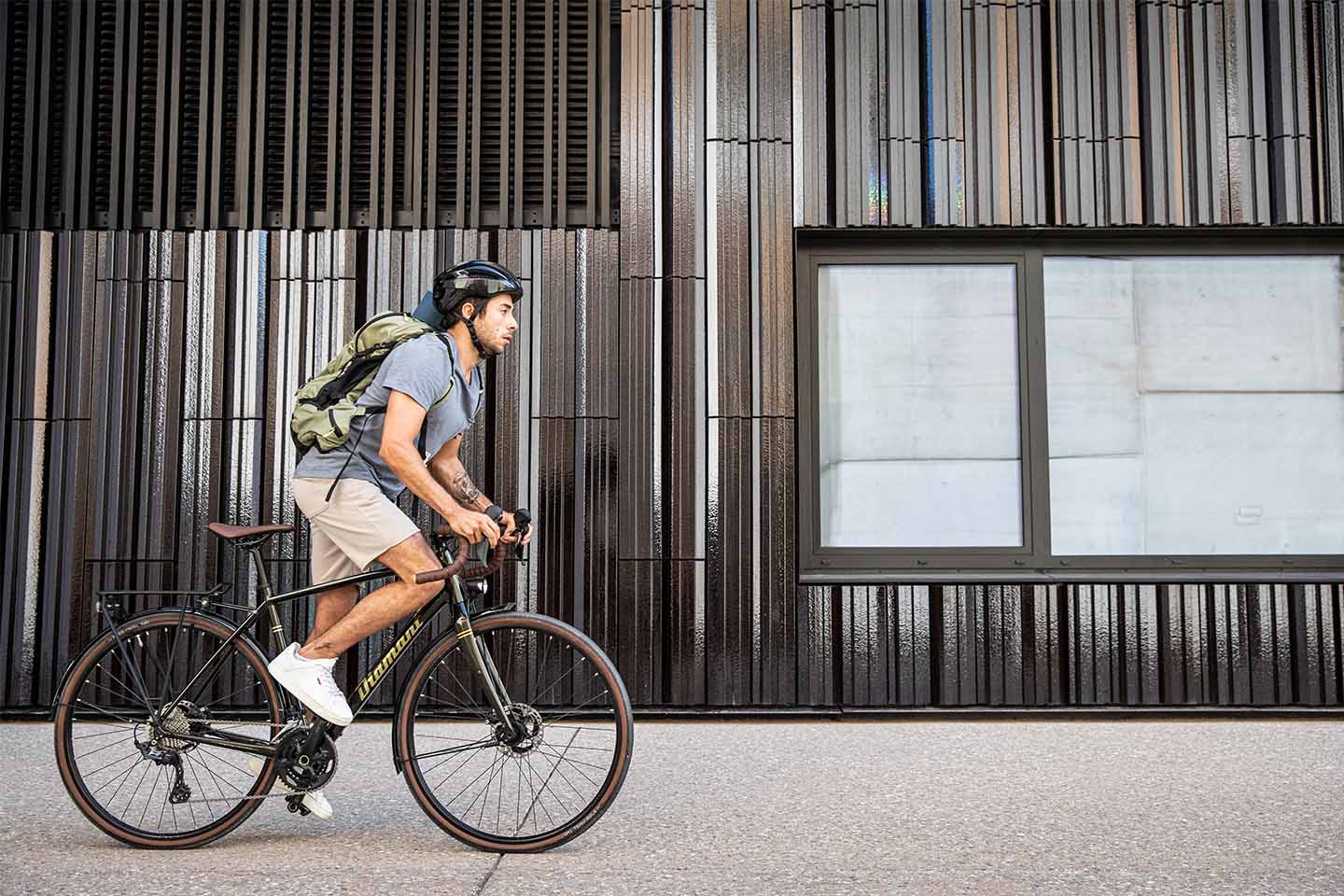 ロードバイクで通勤するライダー。バックパックを背負い、15km以上の距離を一定ペースで走る長距離自転車通勤のイメージ