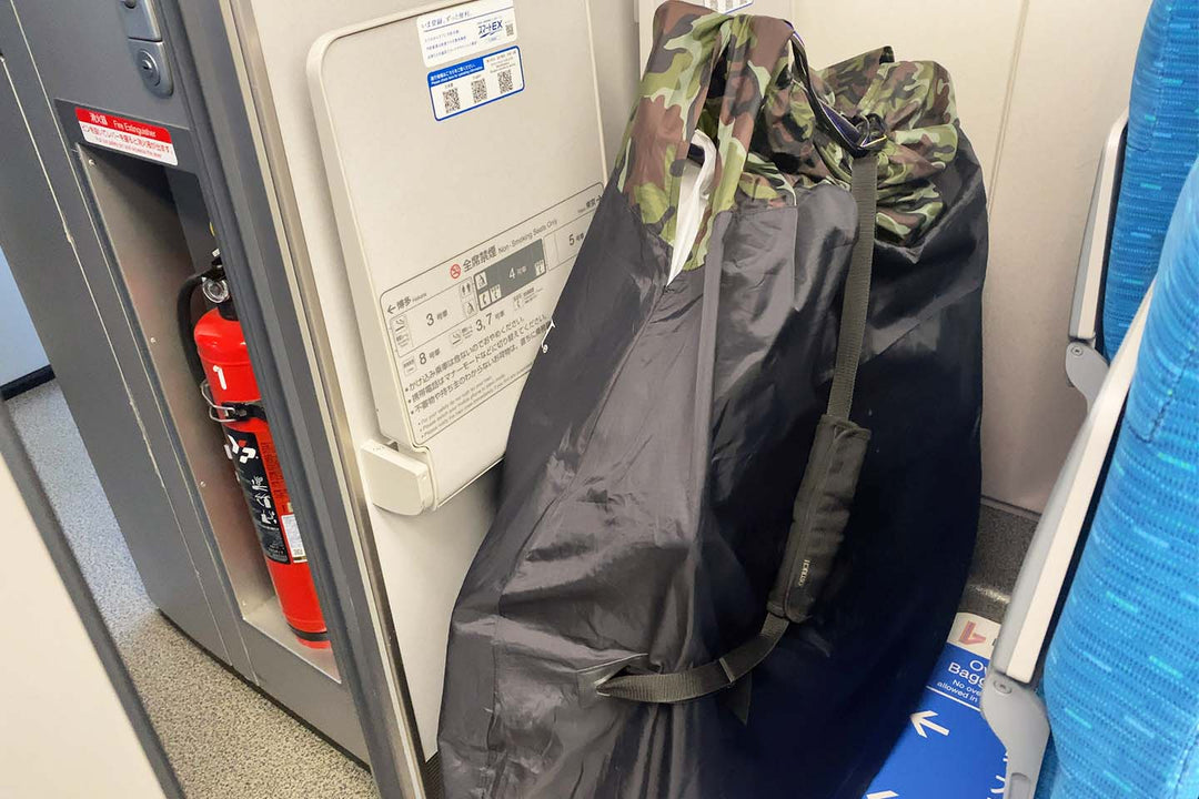 新幹線の特大荷物スペースに輪行袋を置いている写真