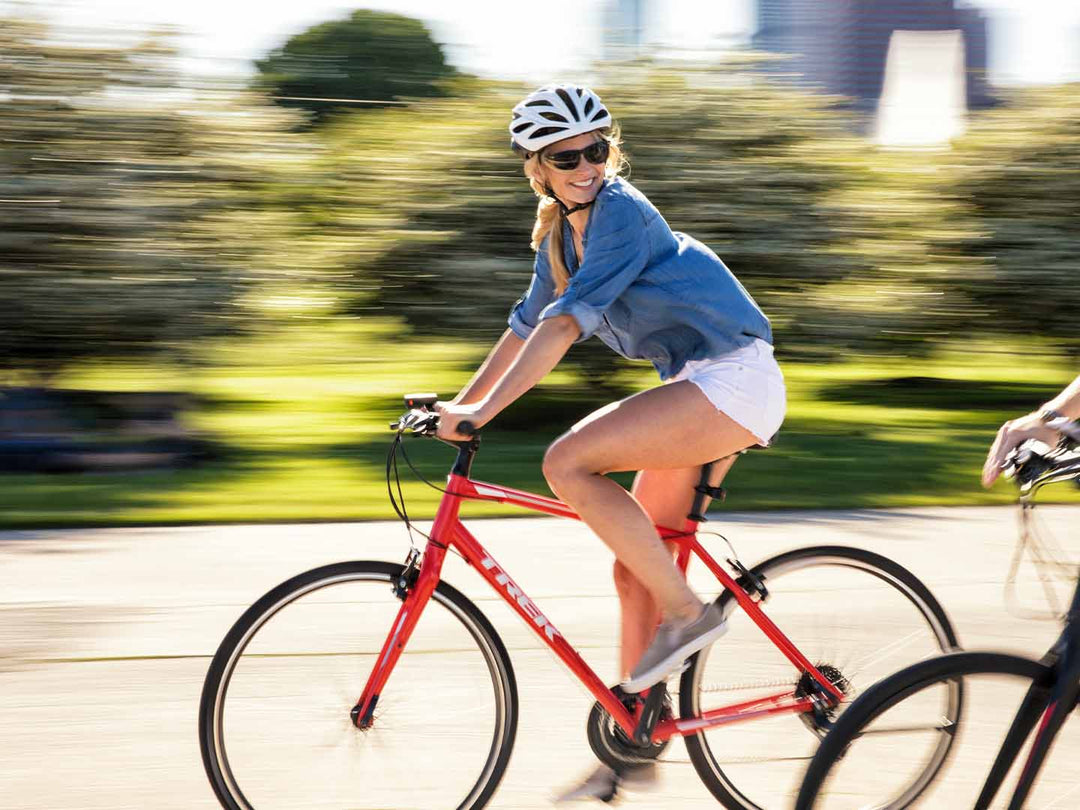 赤いクロスバイクに乗っている女性サイクリストの写真