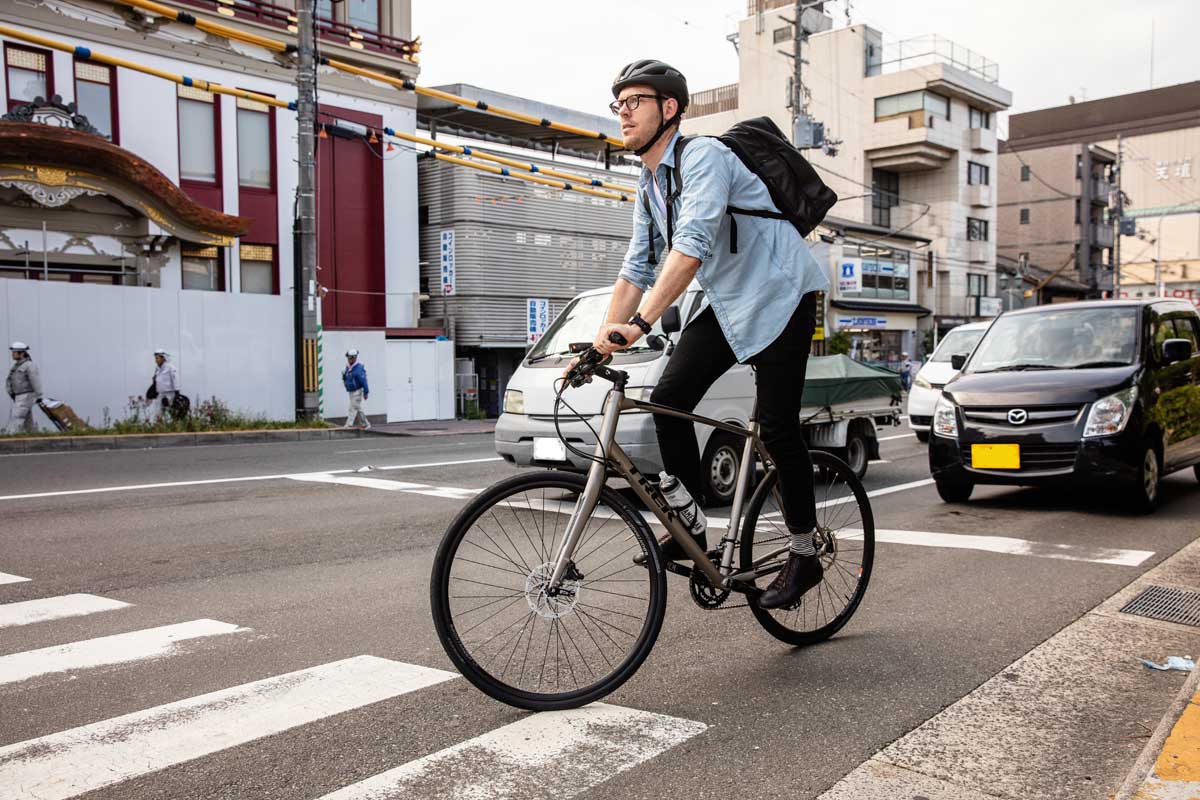 日本の道路でクロスバイク通勤をする外国の男性のライド風景