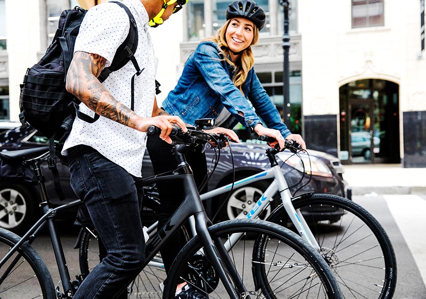 クロスバイクでの自転車通勤中に立ち止まるり笑顔で挨拶する二人の写真
