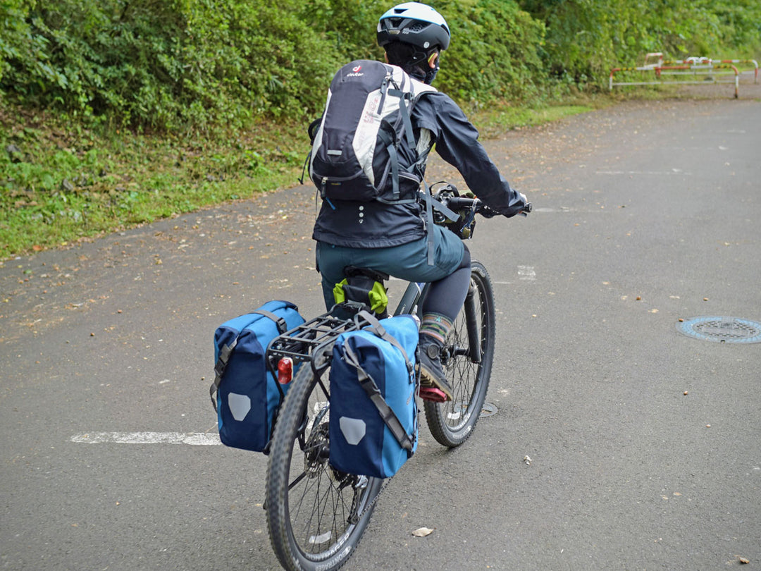 ドイターのバックパックを背負って自転車に乗っている写真